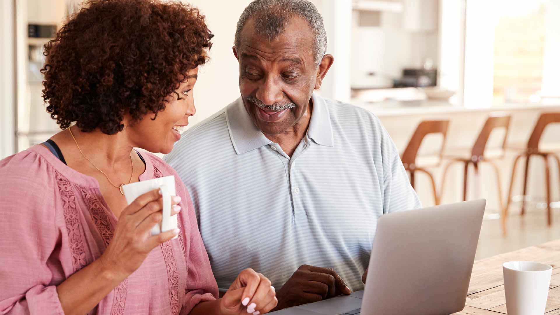 Middle age daughter helping elderly father on laptop